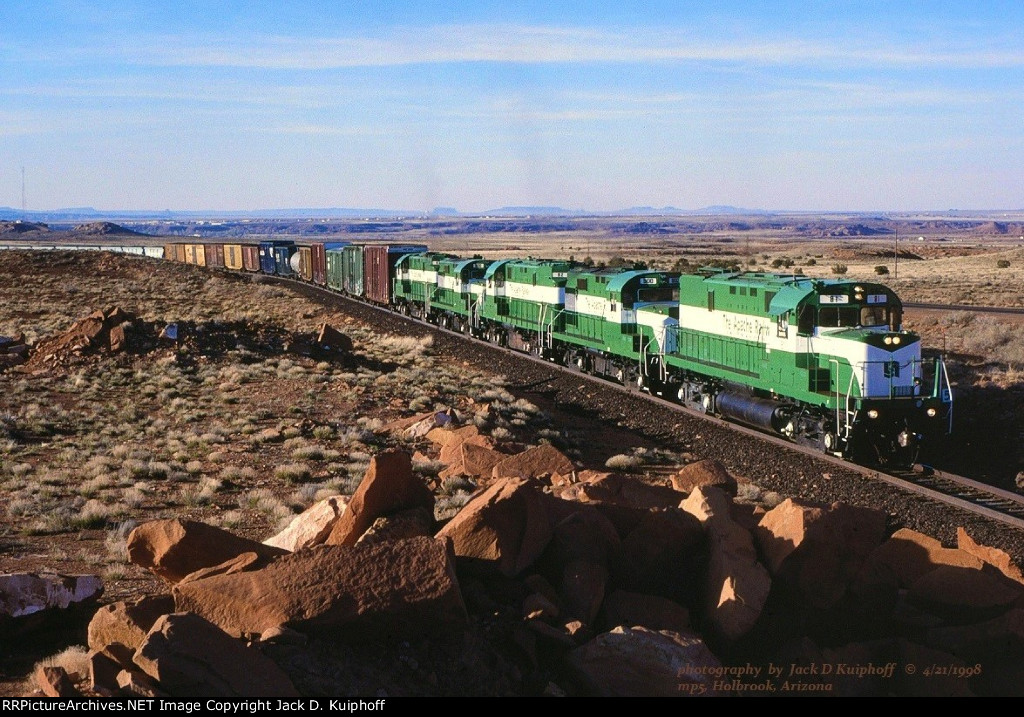 APA, Apache Railway Alcos working hard with 81-900-82-800-83 leading a southbound up grade at mp5 out of Holbrook, Arizona. April 21, 1998. 